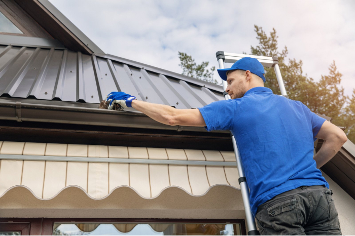 Rang Services technician clearing leaves from a gutter on a Sacramento home